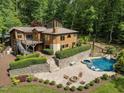 A stunning aerial view showcasing the home's pool, jacuzzi, fire pit, patio, deck, and verdant surroundings at 4312 Mystic Ln, Hillsborough, NC 27278