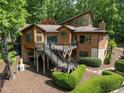 A charming multi-story home with a spacious deck and stairs, surrounded by lush landscaping and mature trees at 4312 Mystic Ln, Hillsborough, NC 27278