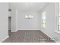 Bright dining room featuring gray wood flooring, a modern chandelier, natural light, and views to the outside at 444 Golden Dragonfly St, Wake Forest, NC 27587
