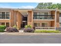 Exterior of a brick condo building with balconies and well-maintained landscaping at 4709 Edwards Mill Rd # H, Raleigh, NC 27612