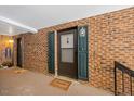Exterior front door with a welcome mat, light fixture, and decorative shutters, set in a brick facade at 4709 Edwards Mill Rd # H, Raleigh, NC 27612