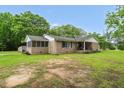 Charming brick ranch-style home featuring a screened porch and covered front porch, nestled on a spacious lot with mature trees at 5129 Neighbors Rd, Mebane, NC 27302