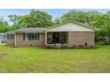 Brick home with inviting front porch, rocking chairs, and landscaping, set on a large lot with mature trees at 5129 Neighbors Rd, Mebane, NC 27302