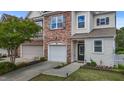 Well-kept townhome showcasing a stone facade, attached garage, and nicely landscaped front yard at 5320 Jessip St, Morrisville, NC 27560
