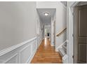 Bright hallway features hardwood floors, wainscoting, and staircase leading to the upper level at 5320 Jessip St, Morrisville, NC 27560