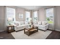 Bright and airy living room with large windows, neutral walls, comfortable sofas, and stylish decor at 700 Tambor Rd, Durham, NC 27713