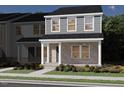 Inviting two-story home featuring a brick facade, covered porch, and landscaped yard at 719 Chandler Stone Dr, Zebulon, NC 27597