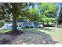 A cozy home surrounded by beautiful mature magnolia and maple trees at 722 Orchard Dr, Graham, NC 27253