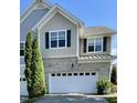 Beautiful two-story townhome showcasing a two-car garage, brick accents, and tidy landscaping at 7241 Terregles Dr, Raleigh, NC 27617