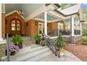 Inviting front porch boasts a brick facade, elegant iron railings, and a beautiful arched wood front door at 801 Pinehurst Dr, Chapel Hill, NC 27517