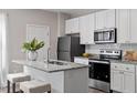 Close-up of the kitchen island featuring granite countertops, seating, and a stainless steel sink at 882 John St, Clayton, NC 27520
