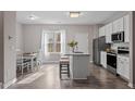 Bright eat-in kitchen with white cabinets, stainless steel appliances, and granite countertops at 886 John St, Clayton, NC 27520