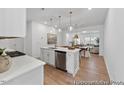 Open concept kitchen featuring stainless appliances, quartz countertops, and open view to the dining and living areas at 92 Horseshoe Pl # 9, Angier, NC 27501