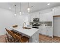 Bright kitchen with white cabinets, stainless appliances, and quartz countertop island with barstool seating at 92 Horseshoe Pl # 9, Angier, NC 27501