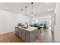 Open concept with a kitchen island, modern pendant lighting, dining, and living room at 92 Horseshoe Pl # 9, Angier, NC 27501