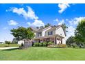 Beautiful two-story home with a lush green lawn, stone-accented flower beds, and a welcoming covered porch at 10 W Ravano Dr, Clayton, NC 27527