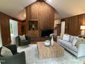 Inviting living room with wood paneled walls, vaulted ceiling, and ample seating at 102 Pebble Ct, Chapel Hill, NC 27516