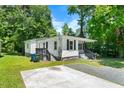View of the home's exterior featuring the front porch, landscaping and driveway at 104 Archdale Dr, Durham, NC 27707