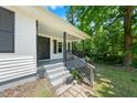 Close up of the home's front porch, entry door, and front yard landscaping at 104 Archdale Dr, Durham, NC 27707