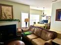 Inviting living room with fireplace, hardwood floors, and neutral tones, flowing into the dining area at 104 Fox Trail Ln, Morrisville, NC 27560