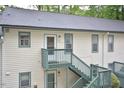 Two-story apartment building featuring painted siding, green trim, and stairs to the second level at 107 Ashley Forest Rd # B, Chapel Hill, NC 27514