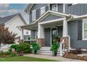 Inviting front porch with stone pillars and carefully placed landscaping, leading to an elegant front door at 109 Big Timber Path, Holly Springs, NC 27540