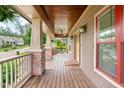 Spacious covered front porch featuring brick columns, a ceiling fan, and wood flooring creating a cozy outdoor space at 111 Streamside Dr, Sanford, NC 27330