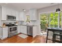 Bright kitchen features stainless appliances, granite counters, and access to a deck at 112 Fairford Dr, Holly Springs, NC 27540