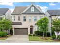 Beautiful two-story home with light brick, a two-car garage, and manicured shrubbery at 113 Mazarin Ln, Cary, NC 27519