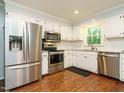 Modern kitchen with stainless steel appliances, white cabinets, and granite countertops at 114 Oxpens Rd, Cary, NC 27513