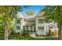 Elegant two-story home with white facade, multiple windows, and a covered porch area with meticulous landscaping at 1208 Hunting Ridge Rd, Raleigh, NC 27615