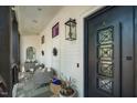 Charming covered porch featuring cozy seating, decorative accents, and a unique black door with ornate glass panels at 1208 Hunting Ridge Rd, Raleigh, NC 27615