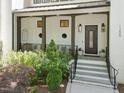 Inviting front porch with stone steps, stylish seating, and manicured landscaping leading to an ornate front door at 1208 Hunting Ridge Rd, Raleigh, NC 27615
