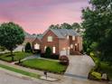 Well-maintained brick home featuring two-car garage and landscaped grounds at dusk at 12140 Pawleys Mill Cir, Raleigh, NC 27614