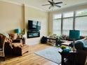 Bright living room with a ceiling fan, fireplace, and large windows offering plenty of natural light at 142 Philips Sq, Chapel Hill, NC 27516