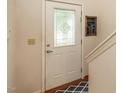 Elegant front door featuring decorative glass panel, complemented by classic hardware and a clean white finish at 1509 Elkpark Dr, Raleigh, NC 27610