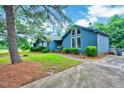 Side view of blue home with large windows and a well-kept lawn on a sunny day at 1732 Farmington Rd, Rocky Mount, NC 27801