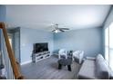 Bright living room with blue walls, modern furniture, and large windows at 1806 Stroll Cir, Fuquay Varina, NC 27526