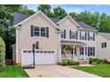Inviting two-story home with a pristine lawn, two-car garage, and classic blue shutters at 201 Forbes Rd, Wake Forest, NC 27587