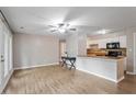 Open concept living room with hardwood floors, ceiling fan, and access to the adjacent kitchen at 2010 Quaker Lndg # 102, Raleigh, NC 27603