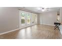 This bright living room features hardwood floors, a ceiling fan, and a sliding door to the exterior at 2010 Quaker Lndg # 102, Raleigh, NC 27603