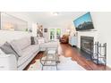 Comfortable living room featuring a cozy fireplace, television, hardwood floors and ample seating at 21 Cedar Hill Dr, Durham, NC 27713