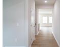 Bright hallway featuring light wood floors and white trim leading to the living areas at 2106 Cherry Creek Road Rd, Haw River, NC 27258