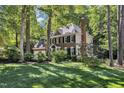 Traditional brick home with lush green lawn and mature trees offering shade at 2125 Oakcrest Ct, Raleigh, NC 27612