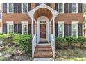 Inviting front entrance with a brick walkway, a charming porch and sidelight windows at 2125 Oakcrest Ct, Raleigh, NC 27612