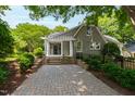 Charming home with brick paved driveway, white pergola and lush landscaping at 2202 St Marys St, Raleigh, NC 27608