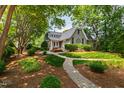 Landscaped front yard with brick pathway leading to charming two-story home at 2202 St Marys St, Raleigh, NC 27608