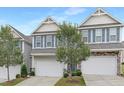Two-story townhomes featuring a two-car garage, gray siding, blue shutters, and landscaped front yards at 222 Explorer Dr # 271, Morrisville, NC 27560