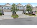 View of three townhomes with two-car garages, gray siding, and blue shutters, showcasing a well-kept street at 222 Explorer Dr # 271, Morrisville, NC 27560