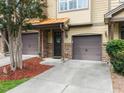 A townhome with a brown garage door, stone accents, and a landscaped front yard, offering curb appeal at 2609 Stewart Pines Dr, Raleigh, NC 27615
